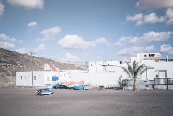 Rolgordijnen white buildings and small boats on beach against blue sky on Fuerteventura, Canary Islands, Spain © Christian Horz