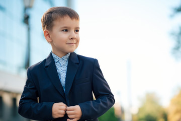 Boy in classic modern dark blue business costume 