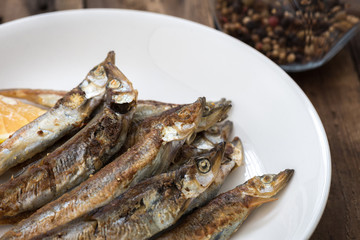 Grilled fish capelin or shishamo on white plate

