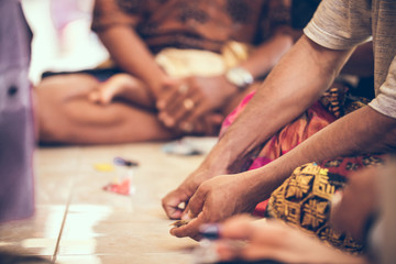 Obraz premium Group of balinese men playing cards sitting on the floor. Bali island.