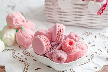 Macaroni with raspberries, marshmallows and kettle with a Cup of hot tea. Selective focus