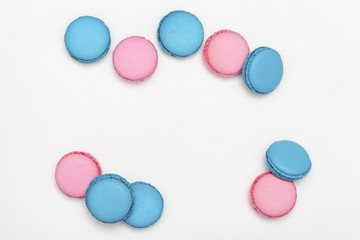 Heap of sweet macaroons of blue and pink color close-up on a white background. Cookies with lavender aroma. Copy space. Selective focus.