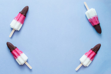 Ice cream popsicles arranged on a pastel colorful background