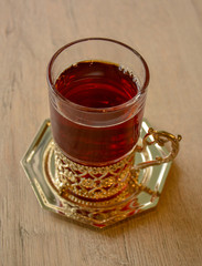 Black tea in transparent glass with metal elements (in oriental style)