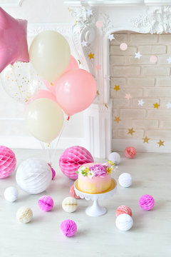 Decorations for holiday party. A lot of balloons pink and white colors. Cake for holiday party.
