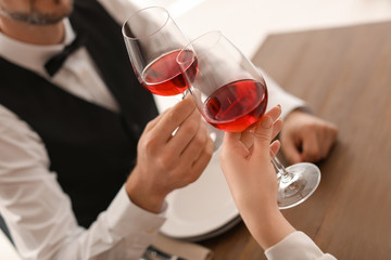 Young couple with glasses of delicious wine in restaurant