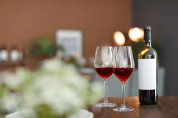Glasses and bottle with tasty wine on table in restaurant