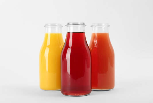 Bottles with delicious colorful juices on white background