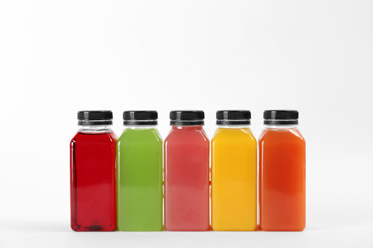 Bottles with delicious colorful juices on white background