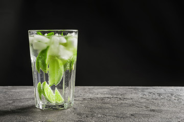 Refreshing beverage with mint and lime in glass on table