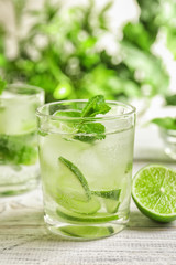 Refreshing beverage with mint and lime on table