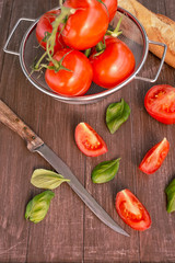 Frische Tomaten liegen in einer Schale auf einem Holztablett