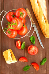 Frische Tomaten liegen in einer Schale auf einem Holztablett