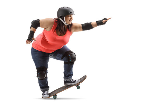 Overweight woman wearing protective gear doing a manual with a skateboard