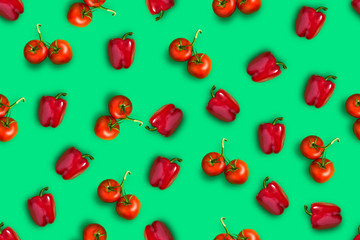 A colorful seamless pattern of red ripe tomatoes and bell peppers on a green background.