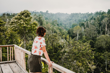 .Young and smiling tourist touring the north of Bali in Indonesia. Making stops in the middle of the jungle and enjoying every moment. Travel photography. Lifestyle.