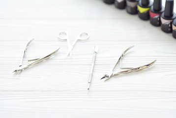 Naklejka premium Top view of manicure and pedicure equipment on white wooden background