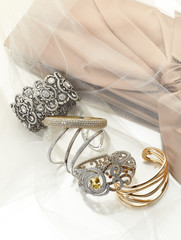 Female gold jewelry with diamonds and a handbag on a white background