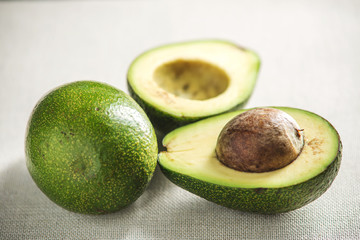 Avocado fruit cut in half on the light background. Concept organic eco products for food and cosmetic procedures