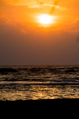 Sonnenuntergang über dem Meer mit Sandstrand