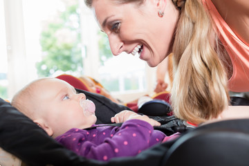 Moms and babies in mother and child course practicing with baby seats