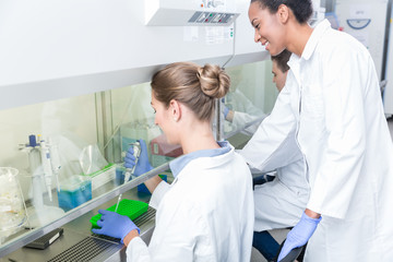 Group of scientists in research laboratory working under splashback