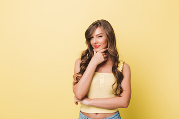 Photo of young woman 20s with long brown hair wearing casual clothing smiling and touching her chin...