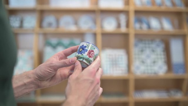 Male hands inspecting small coffee cup