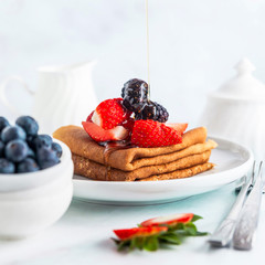 Traditional Ukrainian or Russian pancakes with fresh berries and
