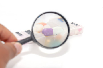 Fototapeta premium magnifying glass with colorful pill in the box