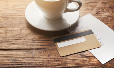 Restaurant bill and credit card on wooden table