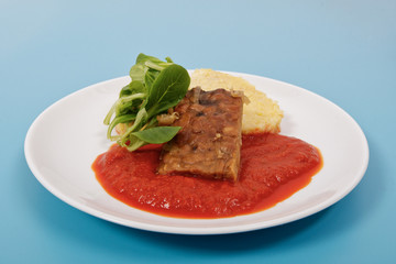 Tempeh with tomato sauce and dumplings on a blue