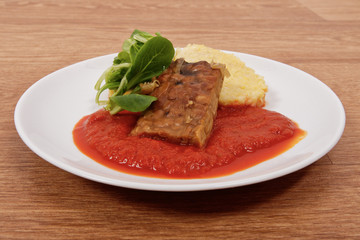 Tempeh with tomato sauce and dumplings on a table