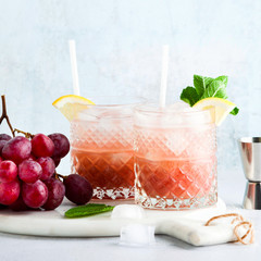 pink alcoholic cocktail of fresh ripe grapes in a shaker with ic