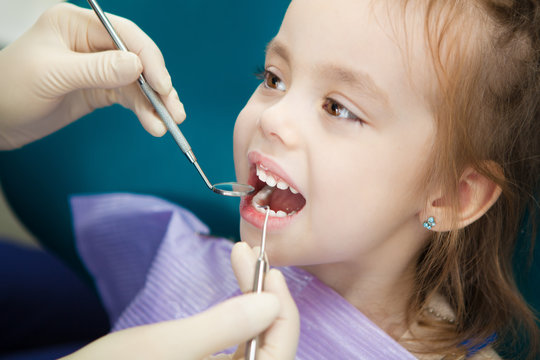 Child Lies In Dentist Chair And Doctor Does Checkup