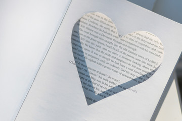 Pages of a book carved into a heart shape for background