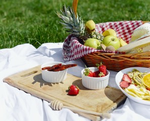Picnic at the park on the grass: healthy food and accessories, top view