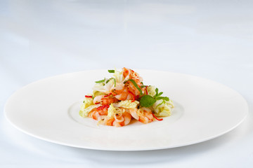 Large, beautiful shrimp with salad on a white plate.