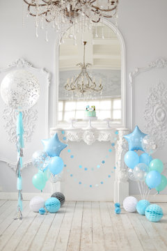 One year birthday decorations. A lot of balloons blue and white colors. Blue stars. Big Balloons. Cake for holiday party. 
