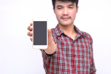 Isolated indoors white background. Hipster Man standing holding mobile phone.
