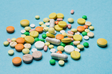 on the blue surface scattered multi-colored tablets, the concept of medicine and allergy