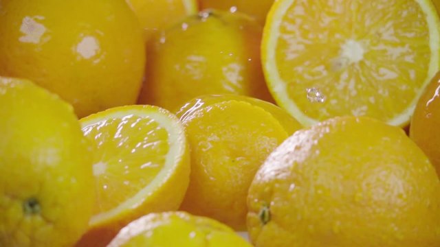 Orange falling in juice with splash between oranges. Slow motion