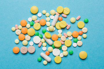 on the blue surface scattered multi-colored tablets, concept medicine and allergy