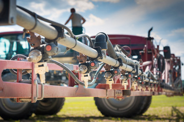nozzles on the spray bar, against the background of the sprayer and the person standing on the barrel, during refueling
