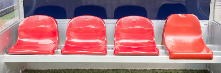 Detail of red Reserve chair and staff coach bench in sport stadium
