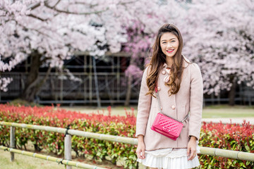 Portrait Beautiful Attractive Asian woman smile with cherry blossom or sakura flower feeling so happiness and cheerful