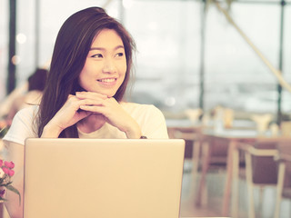 Happy Beautiful Asian young woman working with laptop and smile and looking outside office with positive emotional,Business Startup Concept