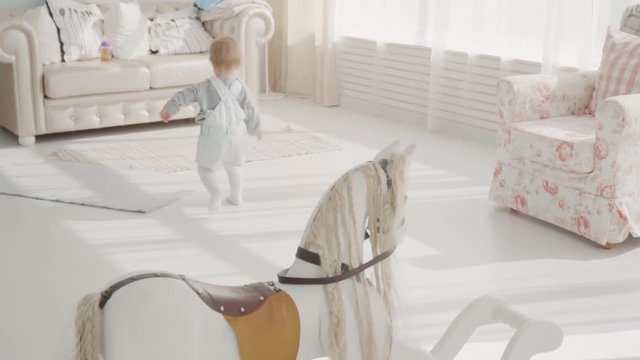 Little lovely baby running around in the room. Happy family. Slow motion