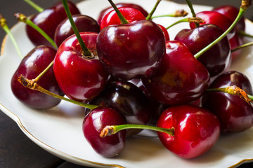 Cherry on a dark background with a sprig of mint. Food photography.