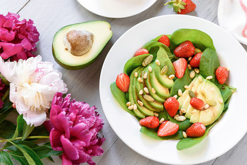 breakfast vegan salad with avocado, strawberries, pine nuts